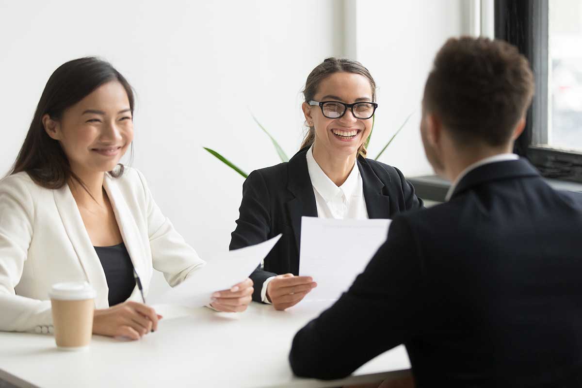 Three people sitting at a table with papers.